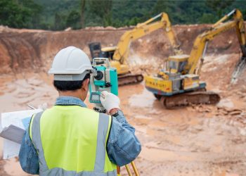 survey engineer in construction site use theodolite checking excavation foundation work